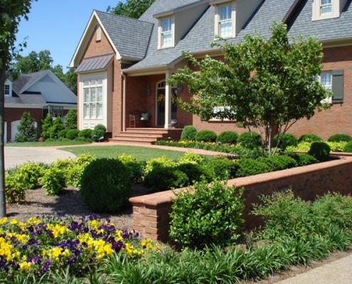 Front yard landscape with garden and masonry wall
