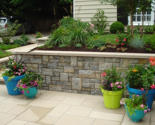 stone masonry wall with flower accent pots