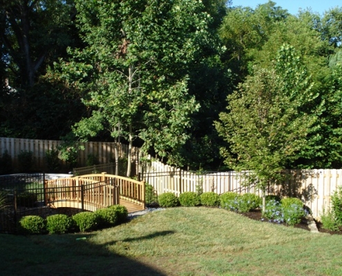 A woodwork bridge in a landscape designed by Dwyer DesignScapes in Louisville, Kentucky