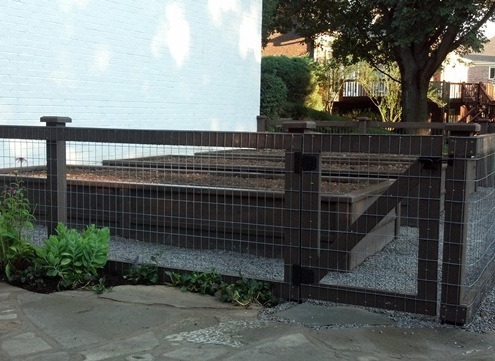 A brown wooden fence with a metal screen