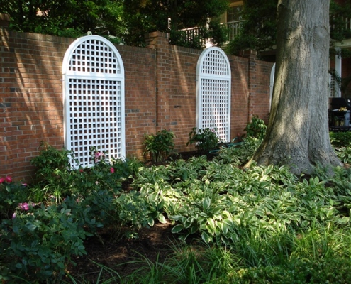 White lattice accenting a large stone wall