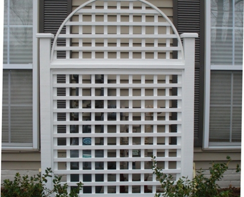 A white lattice piece hiding meters on a home
