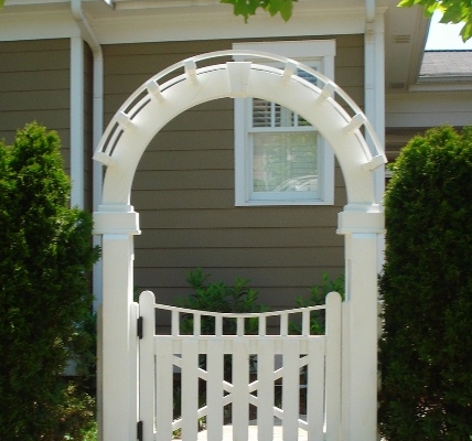 A white wood gate with and archway and lattice.